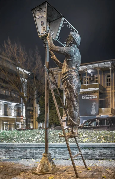 Georgia. Tbilisi. 23 Novembro 2016. Rua Baratashvili. O monumento de bronze do abajur com a sua escada, para modificar uma lâmpada em um poste de luz durante a noite. O trabalho do escultor Irakli Tsuladze . — Fotografia de Stock