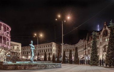 Gürcistan. Tbilisi. Gece şehir arka plan üzerine mimar Shota Kavlashvili heykeli.