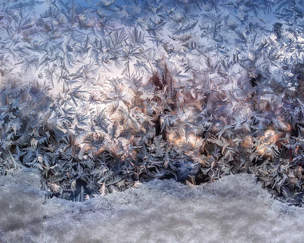 Mroźny wzorców i zaspy na mrożone okna błyszczą w promienie słońca zima — Zdjęcie stockowe