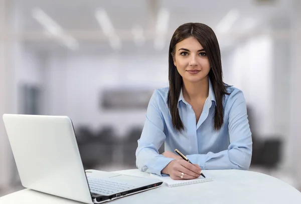 Hermosa mujer de negocios está trabajando detrás de la computadora portátil en la oficina — Foto de Stock