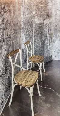 Çatı katı tarzında iç tasarım. Kaba sıva duvarlar, gizli bir kapı ve eski, geri yüklenen sandalye