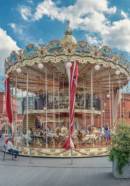 Moskova. Çocuk şenlikli bir iki katlı atlıkarınca Kremlin duvarları yanında binmek. Festivali 