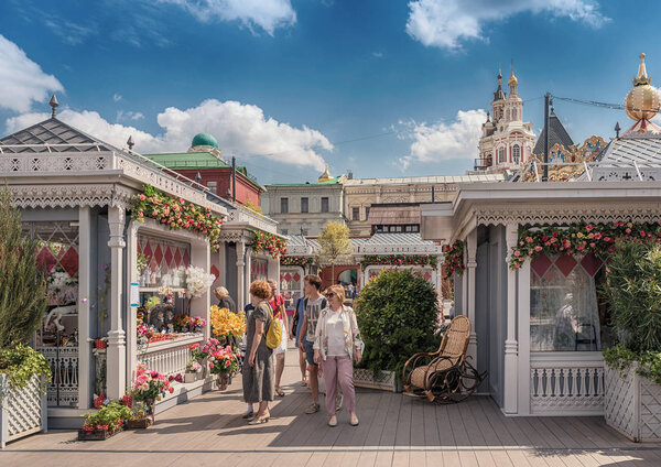 В Москве. Фестиваль "Московское лето, цветочное варенье". Люди ходят между элегантными торговыми павильонами, построенными рядом с площадью Революции
.