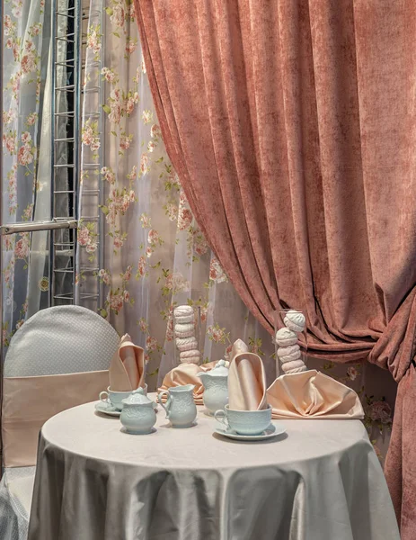 Rahat Oda misafirler için bekliyor. Zarif masa masa örtüsü ile kaplıdır, bir çay seti ve bir tatlı zephyr üstünde o.