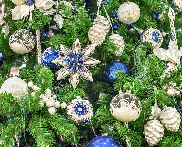 Kerstmis achtergrond. Witte en blauwe ballen en mooie kerst-speelgoed op vuren takken — Stockfoto