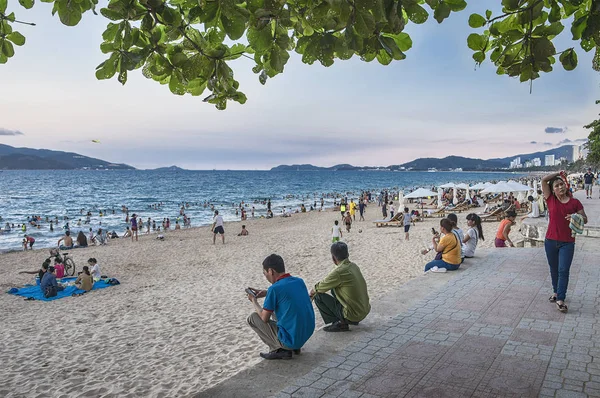 Βιετνάμ, Nha Trang. 28 Απριλίου 2015. Αμμώδης παραλία, σαλόνια μονίππων και ήρεμη θάλασσα. Πολλοί άνθρωποι κάνουν μπάνιο και ηλιοθεραπεία, τα παιδιά παίζουν. — Φωτογραφία Αρχείου