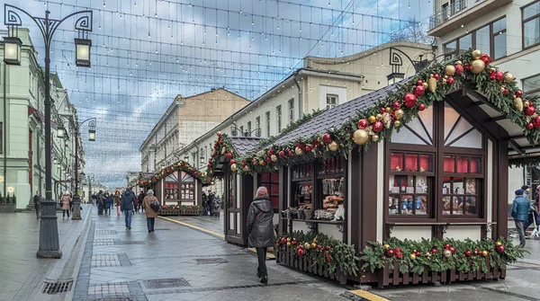 В Москве. 7 января 2017 года: Рождество. Люди идут по Камергерскому переулку. Торговые палатки украшены рождественскими шарами, игрушками и елочными ветвями — стоковое фото