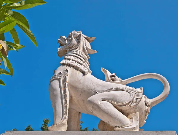 Thailand. Stone statue of Thai lion Singha, or the buddhist Foo Dog Dragon is protect dwelling on the background of the blue sky. — Stock Photo, Image