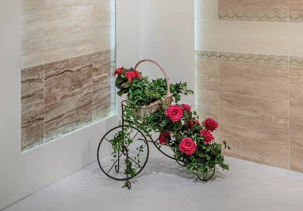 Dekorationsständer für Blumen in Fahrradform ist mit einem Korb mit Blumen, Rosen, Efeu und Bindgras dekoriert. — Stockfoto