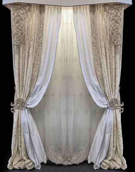 Interior in the palace style. Combined curtains made of golden velor and white satin fabric. Tulle with floral ornament. Knitted pattern from decorative cord — Stock Photo, Image