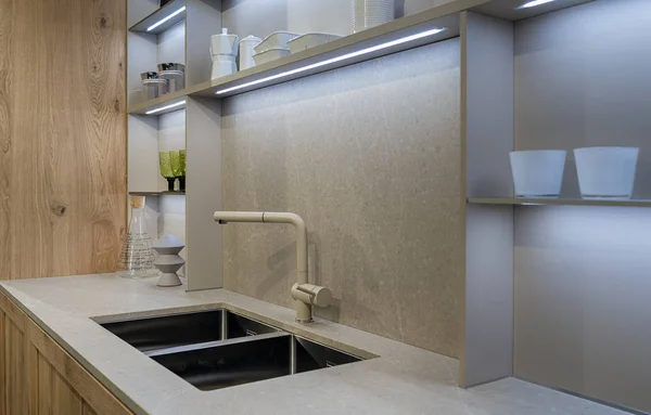 Un fragmento del interior de una cocina moderna con un lavabo de metal doble y luces led incorporadas — Foto de Stock