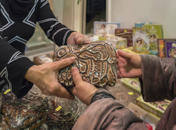 Sale of traditional Tula gingerbread. The Seller passes the delicious gingerbread into the hands of the buyer. On a gingerbread it is written in Russian: Tula