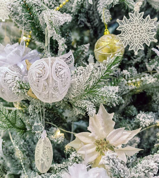 Kerstboom met kunstsneeuw, versierd met witte kantballen, speelgoed en sneeuwvlokken — Stockfoto