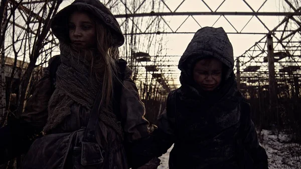 見捨てられた工業地帯を歩いている悲しい汚いホームレスの兄弟 — ストック写真