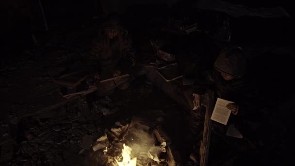 被遗弃建筑中的无家可归的孤儿坐在篝火边 — 图库视频影像