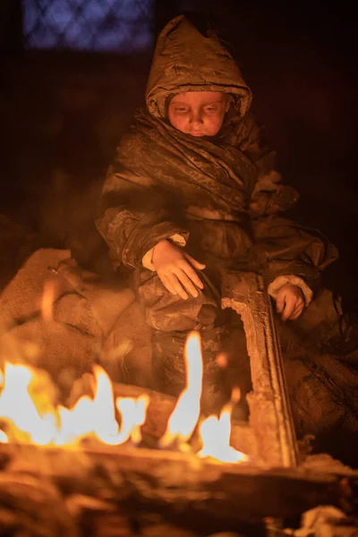 沮丧的无家可归的男孩坐在篝火边 — 图库照片