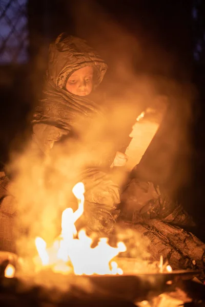 沮丧的无家可归的男孩坐在篝火边 — 图库照片