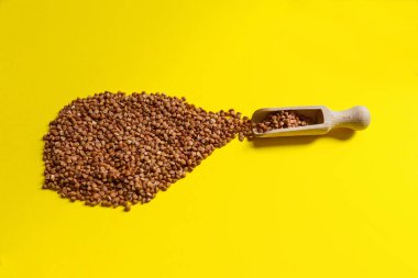 Sarı arka planda bir avuç ürün, karabuğday. Düzgün beslenme, spor, diyet