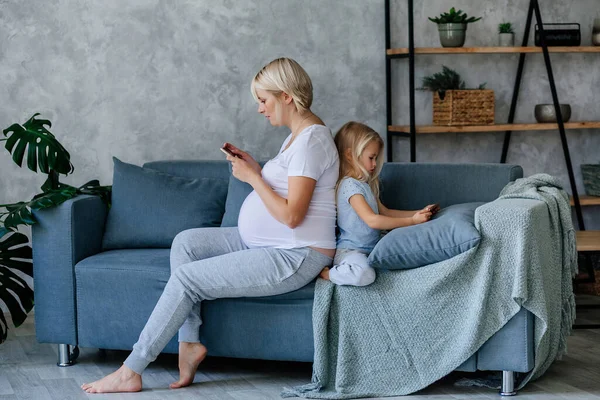 Pregnant Young Girl Sits Sofa Her Little Daughter Back Back — Stock Photo, Image