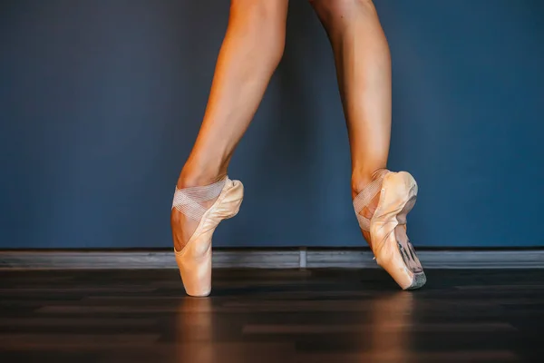 Nogi baletnic w szpiczastych butach, na ciemnym tle, zbliżenie — Zdjęcie stockowe