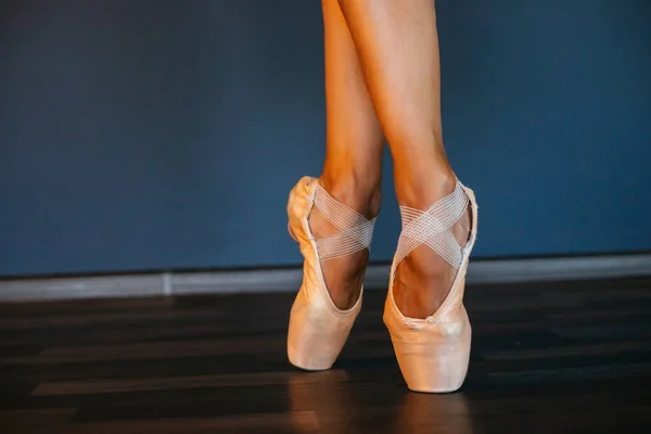 Benen van ballerina 's in puntschoenen, op donkere achtergrond, close-up — Stockfoto