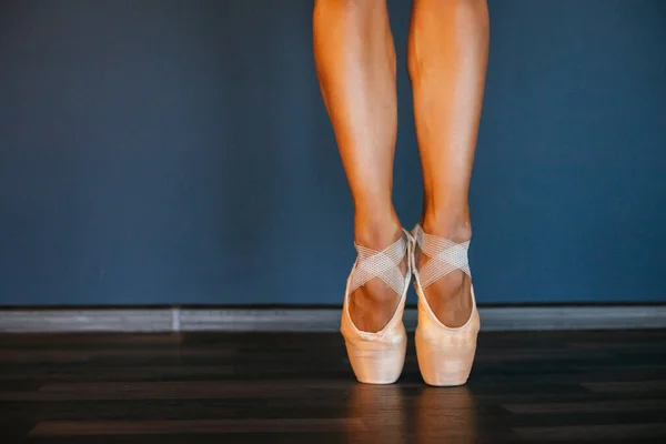 Nogi baletnic w szpiczastych butach, na ciemnym tle, zbliżenie — Zdjęcie stockowe
