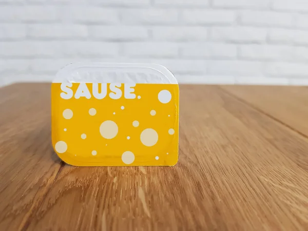 packaging of cheese sauce on a wooden table