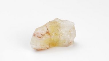 Beyaz arka planda sitrin. Mineral. Döndürme. Dekoratif ve süs taşı. Nugget yakın çekim görüntüsü. Mücevher..