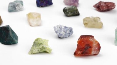 Beyaz arka planda mineraller. Döndürme. Dekoratif taşlar. Gemoloji Mücevherat. Klitoterapi.