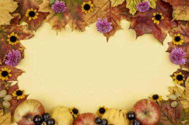 Sarı arka planda sonbahar yaprakları, çiçekler ve meyveler.