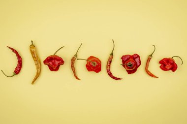 Sarı arka planda baharatlı kurutulmuş çan ve kırmızı biber..