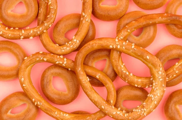 Large and small bagels on a pink background. — Stock Photo, Image