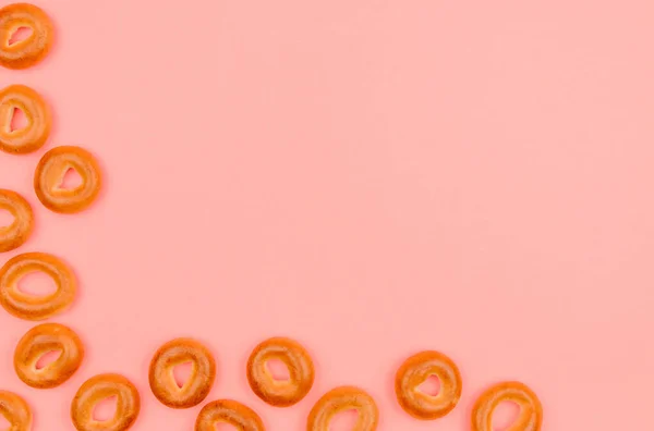 Kleine bagels gelegen de hoek op een roze achtergrond. — Stockfoto