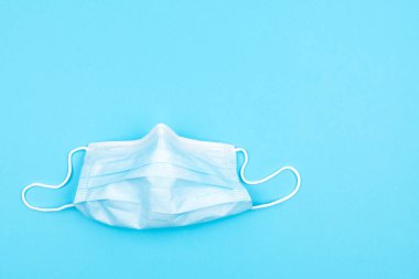 Mavi arka planda koruyucu tıbbi maske. Grip ve soğuk algınlığı.
