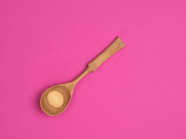 Pembe arka planda tahta kaşık. Yukarıdan manzara. Geleneksel tahta kaşık