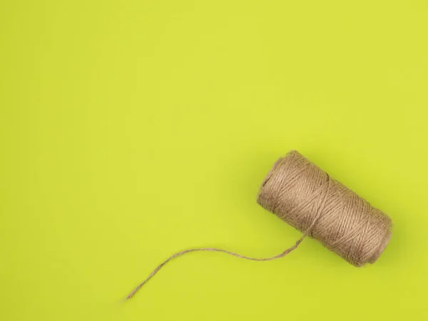 Coil of jute rope on a green background. The view from the top.