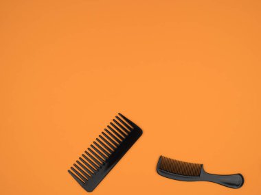 Turuncu arka planda iki plastik tarak. Kuaför aksesuarı.