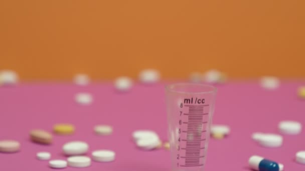 Tabletten und Messbecher für Medikamente. — Stockvideo