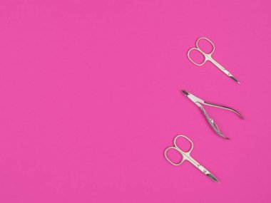 Pembe arka planda makas ve makas. Yukarıdan manzara. Manikür ve pedikür için aksesuarlar.