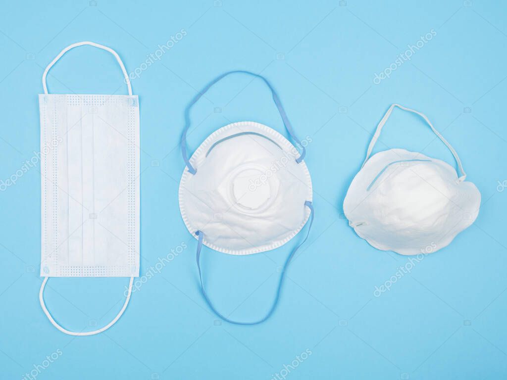 Medical personal protective equipment on a blue background. Mask and respirators. The view from the top.