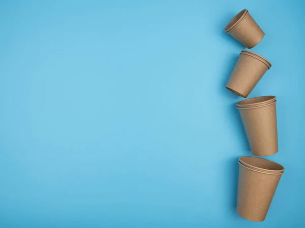 Paper cups on a blue background. The view from the top. Disposable ware.