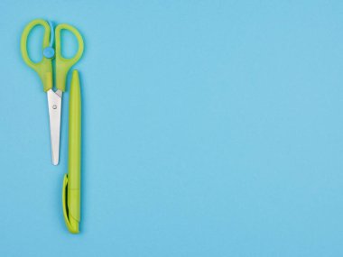 Açık mavi arka planda yeşil kırtasiye malzemesi. Yukarıdan görünüşü.