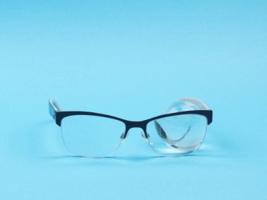 Mavi arka planda gözlük yakın plan. Yukarıdan manzara. Bakış açısı. Cam küre.