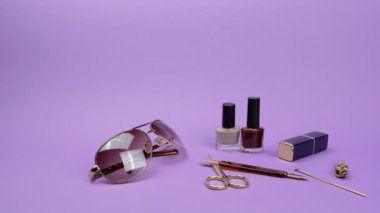 Mor arka planda kadın aksesuarları ve tırnak aksesuarları..