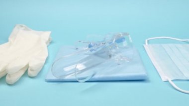 Teftiş için jinekoloji seti ve mavi arka planda kişisel koruma ekipmanları..