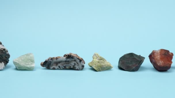 Lot unprocessed natural stones on a blue background. — Stock Video