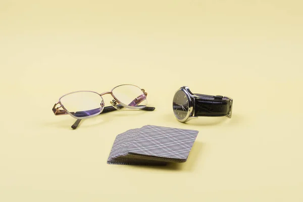 Óculos, relógios de pulso com pulseira de couro e baralho de cartas . — Fotografia de Stock