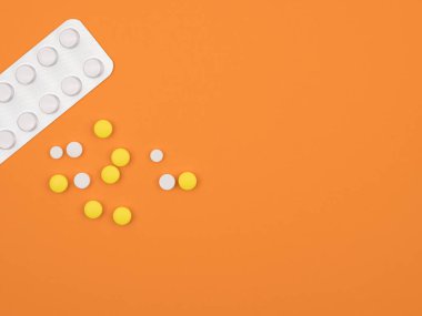 Su toplayan tabletler turuncu arka plana saçılmış..