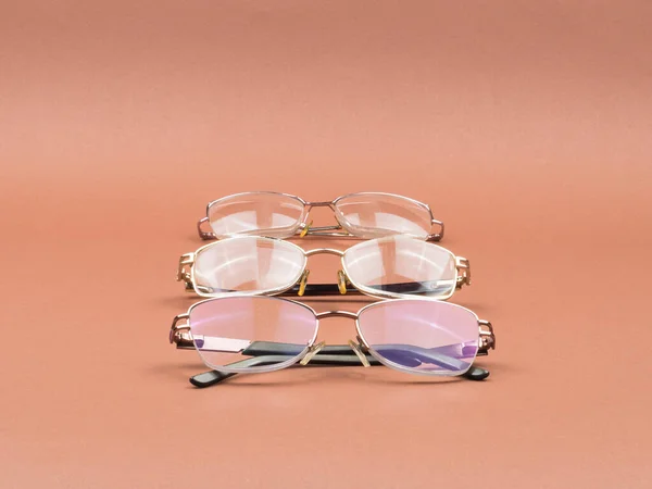 Gafas - un accesorio para una mejor visión sobre un fondo marrón . — Foto de Stock