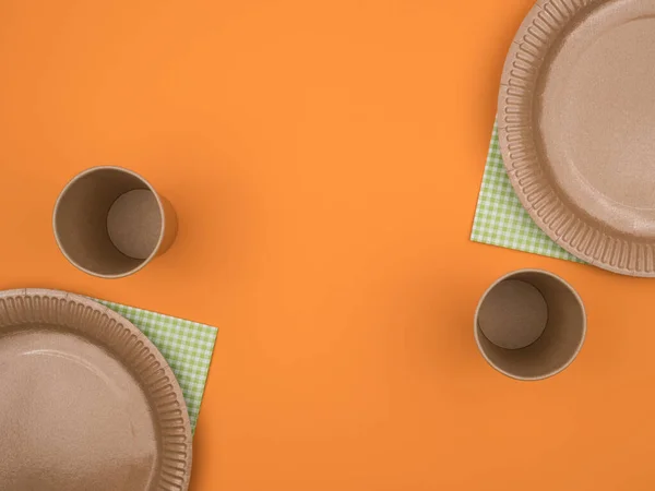 Одноразовая посуда из картона на оранжевом фоне . — стоковое фото